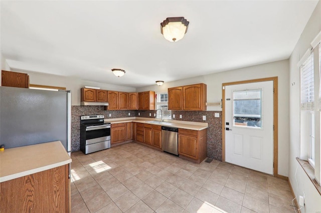 kitchen with tasteful backsplash, appliances with stainless steel finishes, sink, and light tile patterned floors