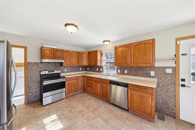 kitchen featuring stainless steel appliances, sink, and light tile patterned floors