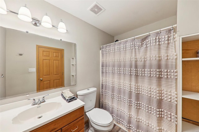 bathroom featuring vanity, toilet, and walk in shower