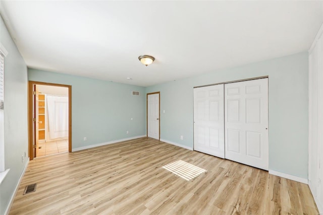 unfurnished bedroom featuring light wood-type flooring and a closet