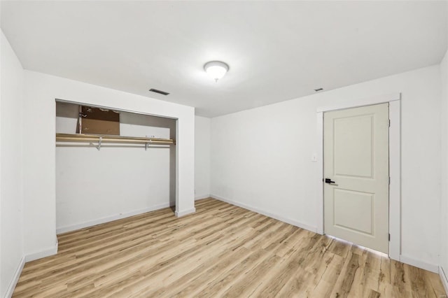 unfurnished bedroom featuring light wood-type flooring and a closet