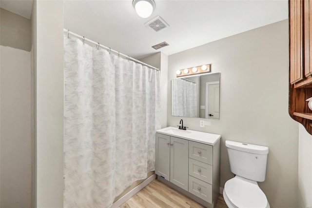 bathroom featuring vanity, toilet, and hardwood / wood-style floors