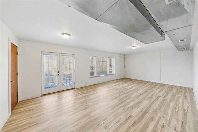 empty room with french doors and light wood-type flooring