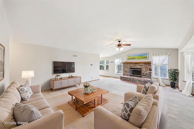 living room featuring a fireplace, vaulted ceiling, light colored carpet, and ceiling fan