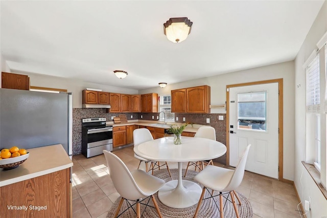 kitchen featuring tasteful backsplash, sink, stainless steel appliances, and light tile patterned flooring