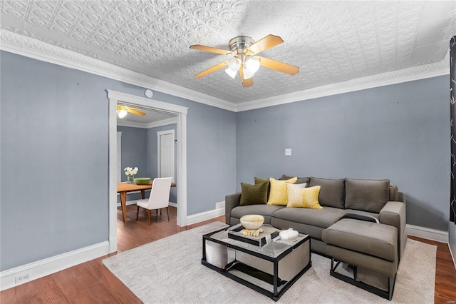 living room with hardwood / wood-style floors, ornamental molding, and ceiling fan