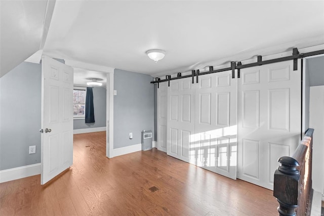 interior space featuring a closet, a barn door, and light wood-type flooring