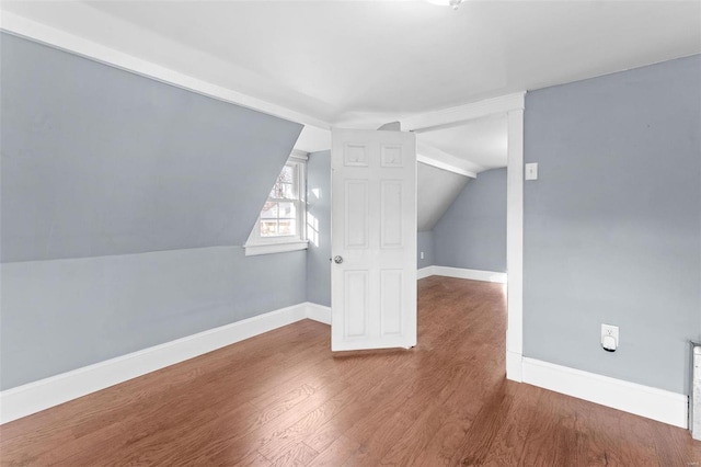 additional living space featuring wood-type flooring and lofted ceiling