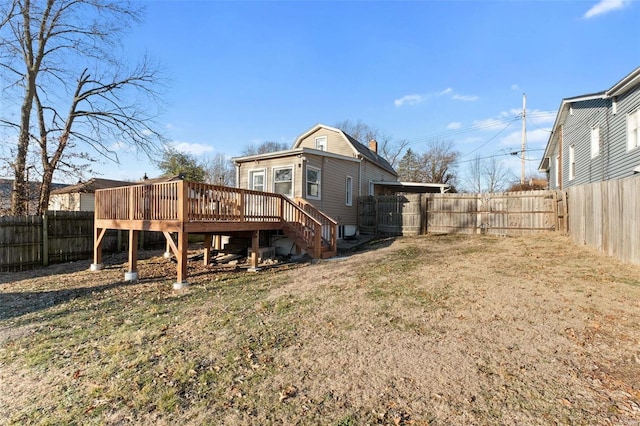 back of house featuring a wooden deck and a lawn