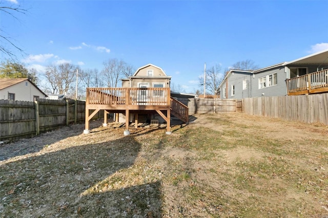 rear view of property with a wooden deck and a yard