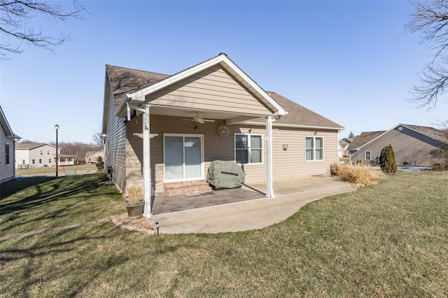 back of house featuring ceiling fan, a patio, and a yard