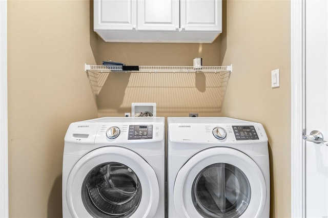 washroom with independent washer and dryer and cabinets