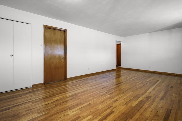 unfurnished bedroom featuring dark wood-type flooring and two closets