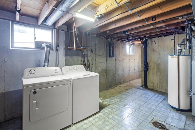 clothes washing area with separate washer and dryer, electric panel, and gas water heater