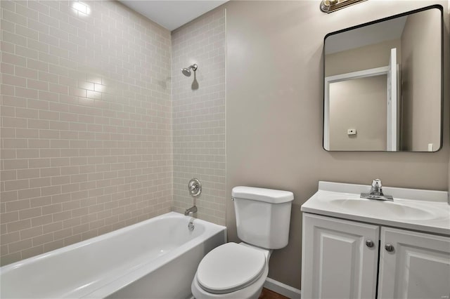 full bathroom featuring tiled shower / bath combo, vanity, and toilet