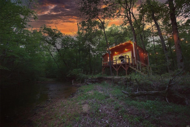 yard at dusk featuring a wooden deck