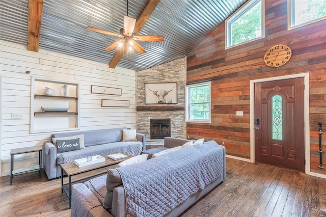 living room featuring wood-type flooring, beam ceiling, wood walls, and high vaulted ceiling