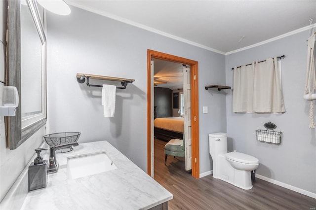 bathroom featuring toilet, vanity, wood-type flooring, and crown molding