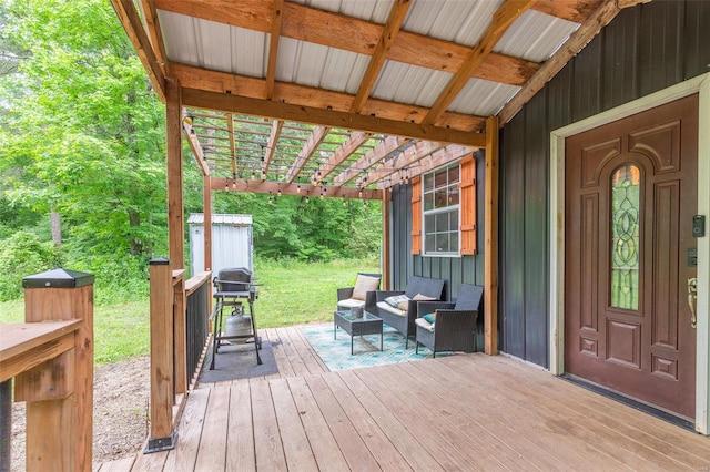 wooden terrace with an outdoor living space, a grill, and a storage shed