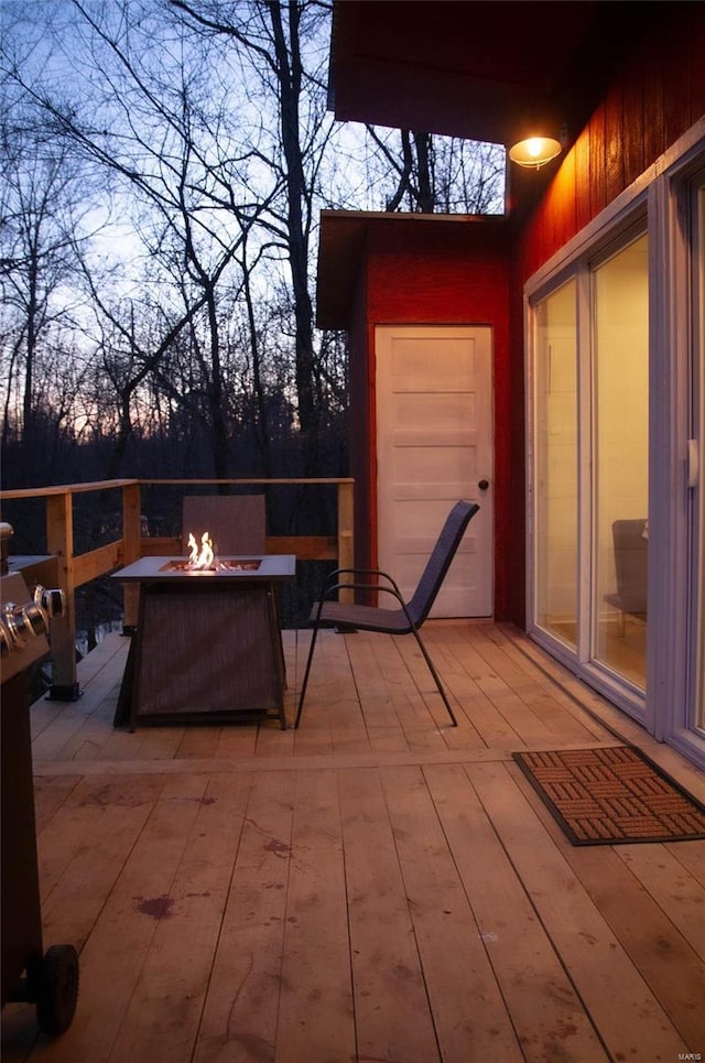 deck at dusk featuring a fire pit