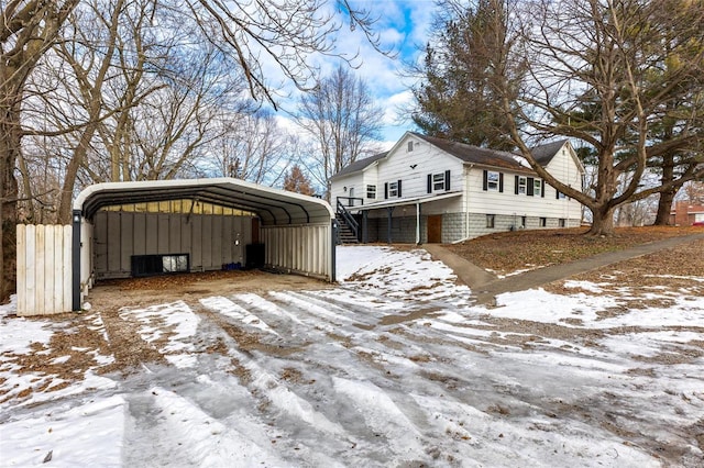 view of snowy exterior with a carport