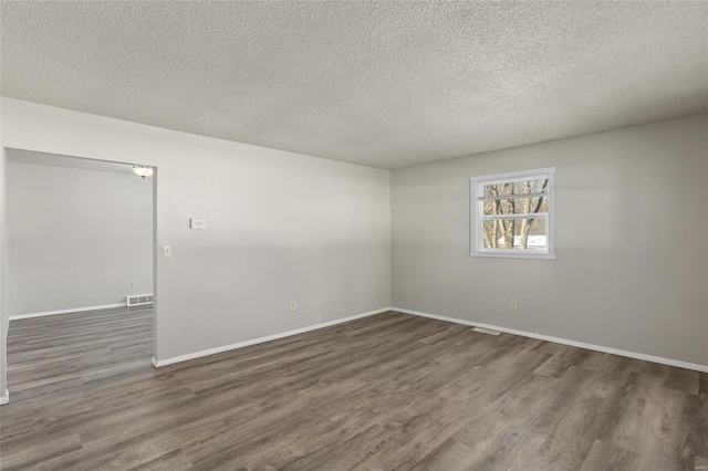 spare room with dark wood-type flooring and a textured ceiling