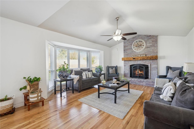 living room with ceiling fan, light hardwood / wood-style floors, a fireplace, and lofted ceiling