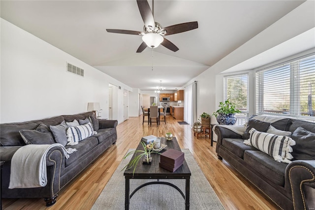 living room featuring light wood-type flooring, vaulted ceiling, and ceiling fan