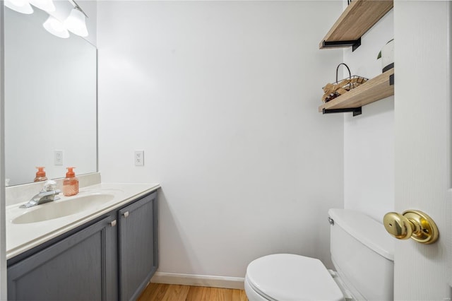 bathroom with hardwood / wood-style flooring, toilet, and vanity