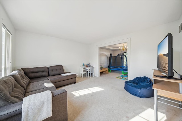 living room with carpet flooring and an inviting chandelier