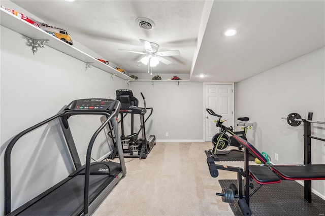 exercise room with ceiling fan and light carpet