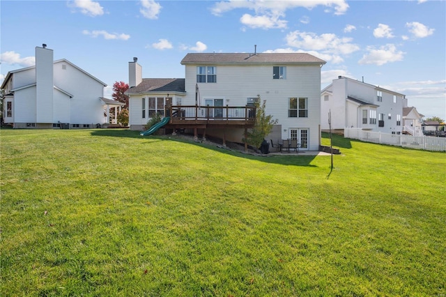 rear view of house featuring a deck and a yard