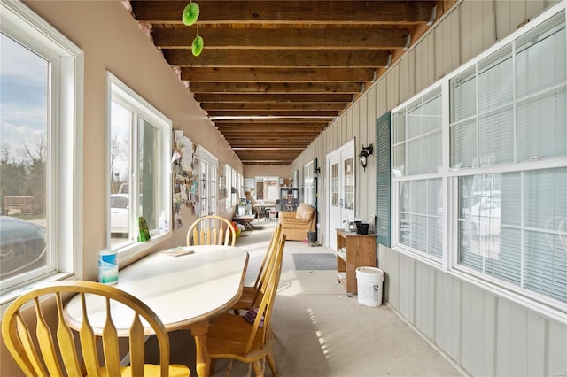 unfurnished sunroom featuring beamed ceiling