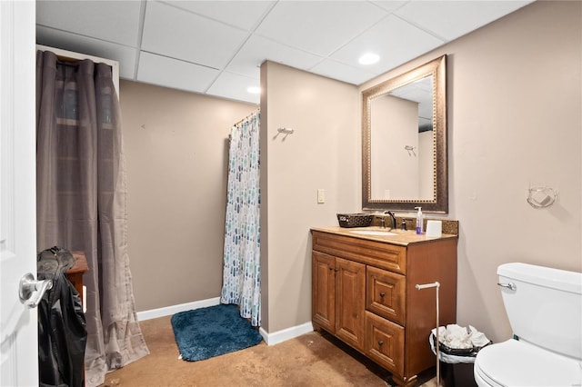 bathroom with vanity, a drop ceiling, and toilet