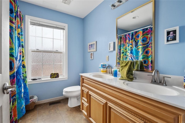 bathroom featuring vanity, tile patterned floors, and toilet