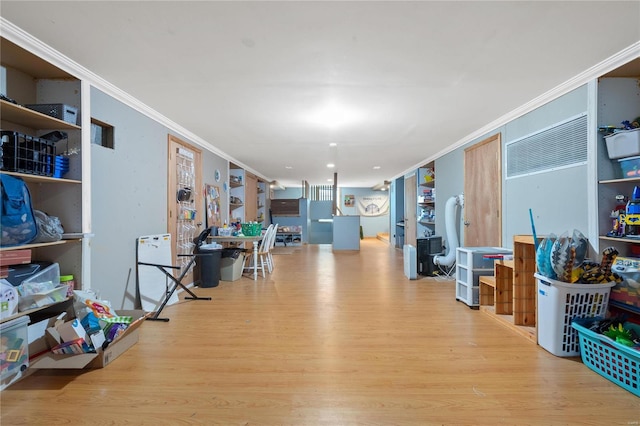 interior space with ornamental molding and light hardwood / wood-style floors