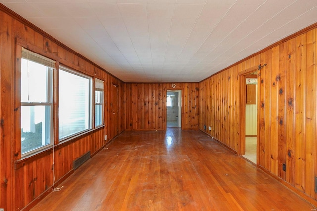 unfurnished room featuring hardwood / wood-style flooring and wooden walls