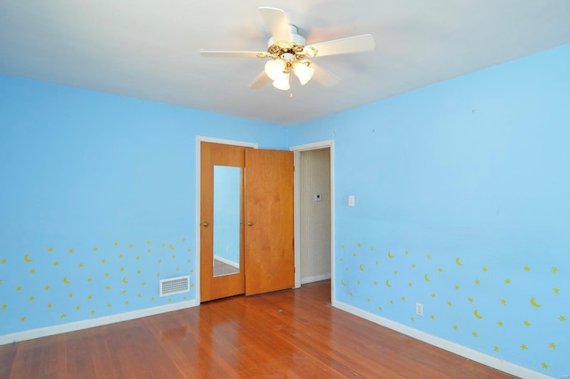 empty room featuring ceiling fan and hardwood / wood-style floors