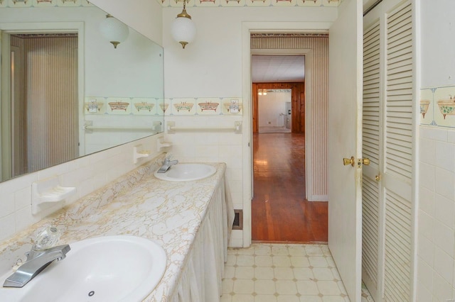 bathroom featuring vanity and tile walls