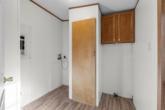 clothes washing area with cabinets, washer hookup, light hardwood / wood-style floors, crown molding, and a textured ceiling