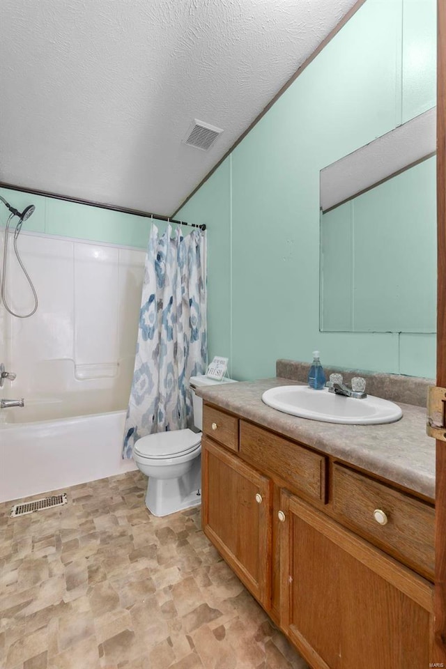 full bathroom featuring vanity, toilet, a textured ceiling, and shower / bath combo