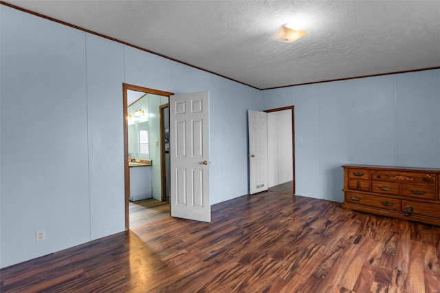 unfurnished room with crown molding, dark wood-type flooring, and a textured ceiling