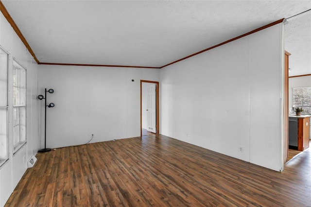 unfurnished room featuring crown molding, plenty of natural light, dark wood-type flooring, and a textured ceiling