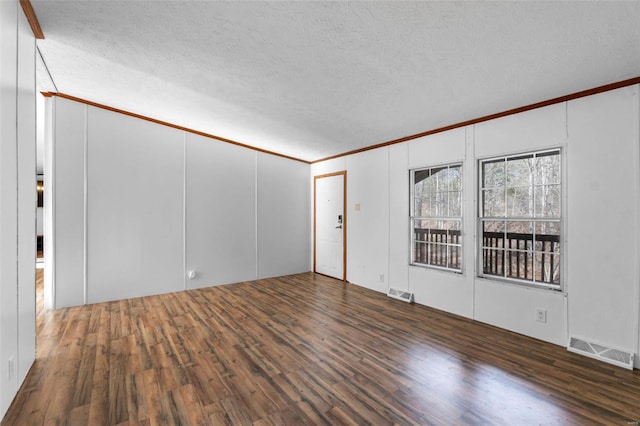 empty room with ornamental molding, dark wood-type flooring, and a textured ceiling