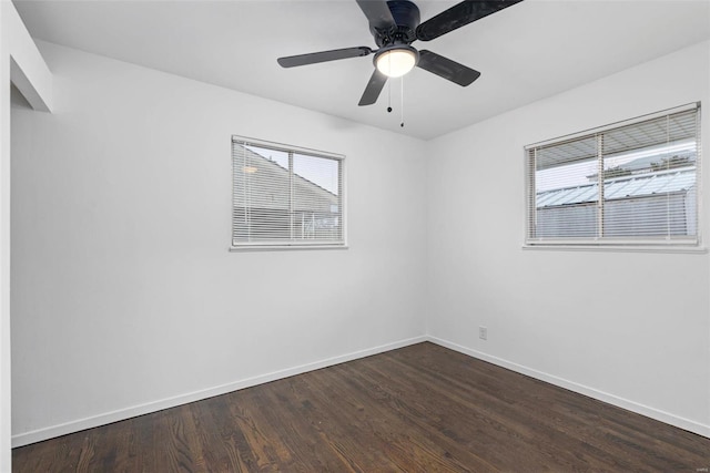 spare room with dark wood-type flooring and ceiling fan