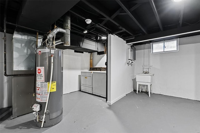 basement featuring sink, washing machine and dryer, heating unit, and gas water heater