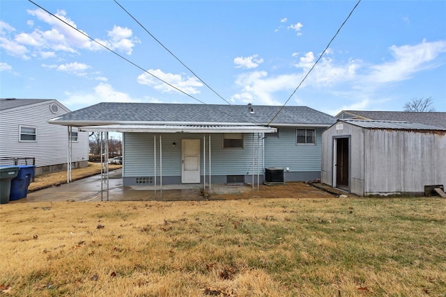 rear view of property with central AC unit, a lawn, a carport, and a storage unit