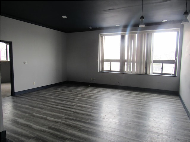 empty room with dark hardwood / wood-style flooring and a healthy amount of sunlight