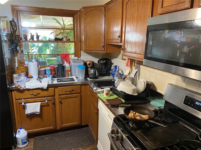 kitchen with sink, backsplash, and appliances with stainless steel finishes