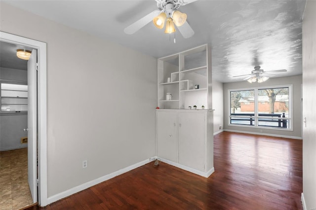 unfurnished room featuring hardwood / wood-style flooring, built in features, and ceiling fan